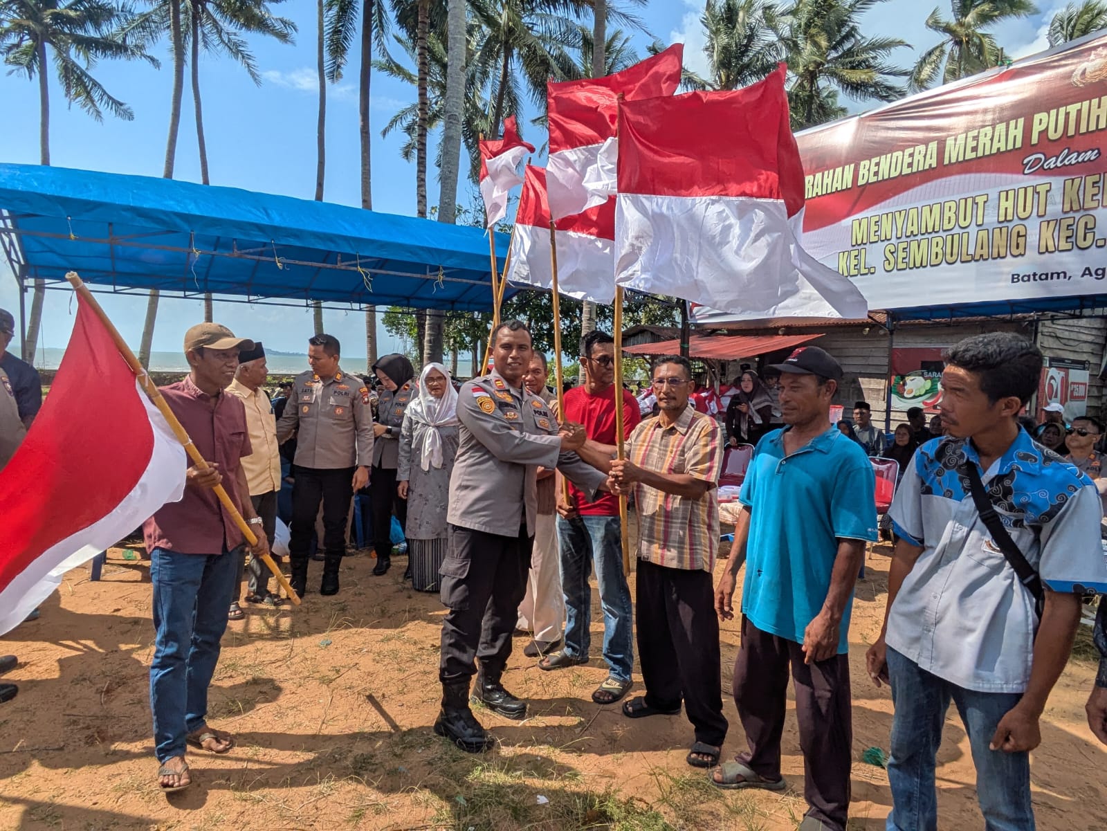Kapolsek Galang Iptu Hendrizal Menyerahkan Bendera Kepada Perwakilan Warga Sembulang, Kecamatan Galang
