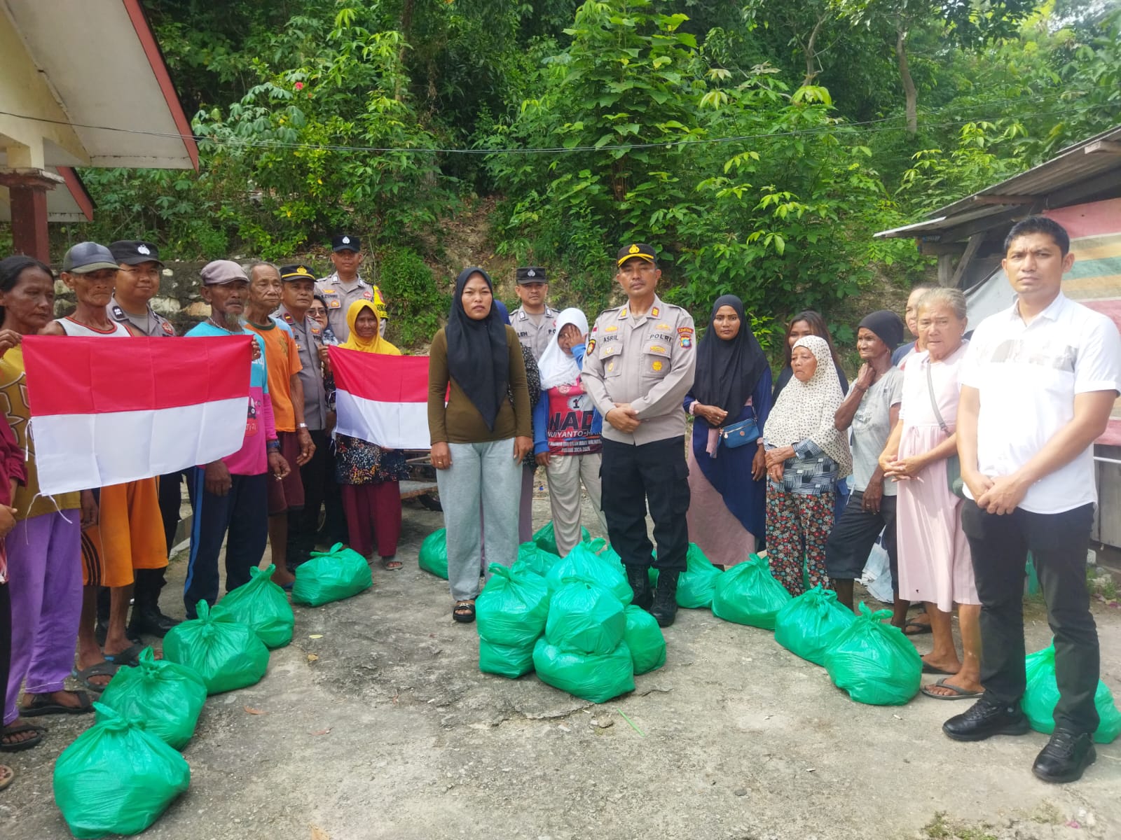 Kapolsek Belakang Padang Akp Asril Bersama Warga Saat Membagikan Paket Sembako Dan Bendera Merah Putih.